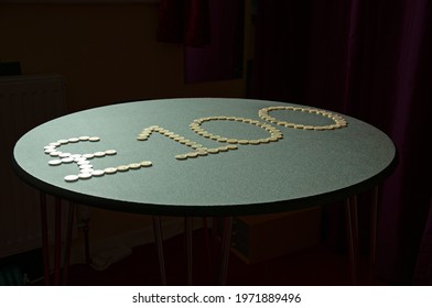 One Hundred Pound Coins On A Round Table.