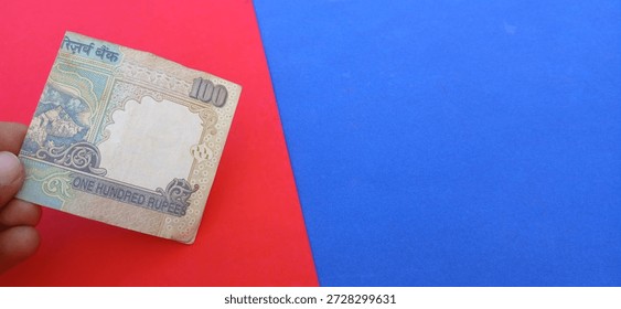 One hundred rupees indian note with red and blue background