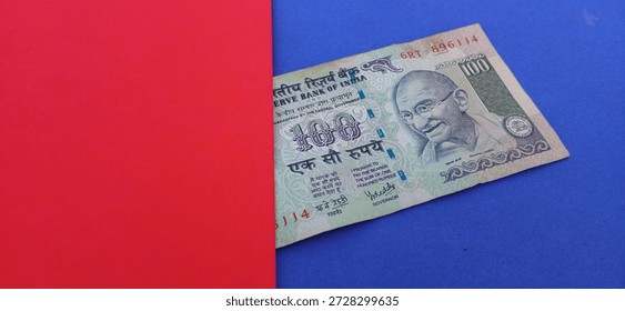 One hundred rupees indian note with red and blue background