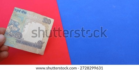 One hundred rupees indian note with red and blue background