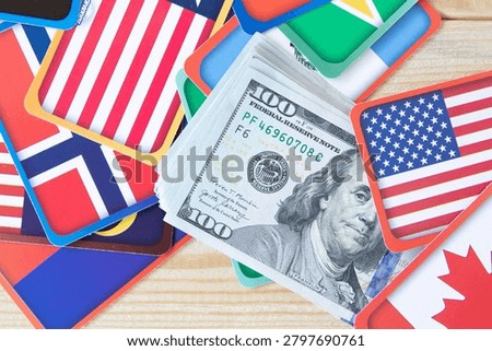 One Hundred US Dollar Banknotes with International Flags Representing Global Finance and Trade