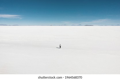 One isolated male tourist enjoying endless boundless infinite vastness width expanse of white salt flat lake Salar de Uyuni in Potosi Bolivia South America - Shutterstock ID 1964568370