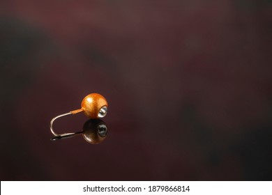 One Jig Head For Ice Fishing With Glass Reflection And Blue Bead