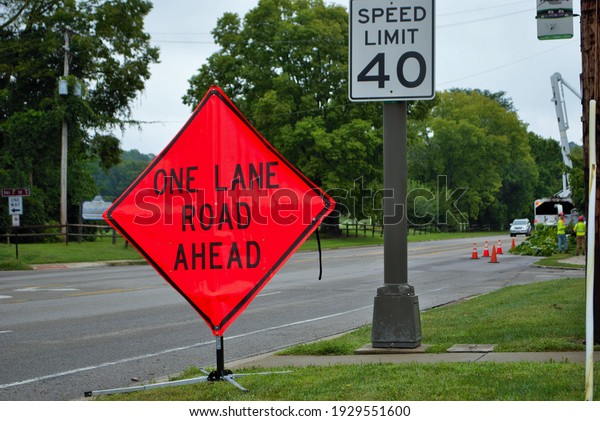 One lane road ahead construction sign on the side of\
a five lane road