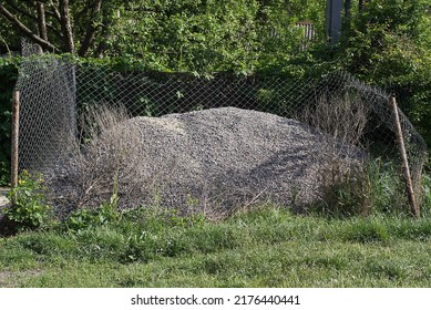 One Large Gray Pile Of Rubble From Small Stones On Green Grass On The Street 