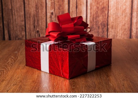 one large red gift box on a wood background