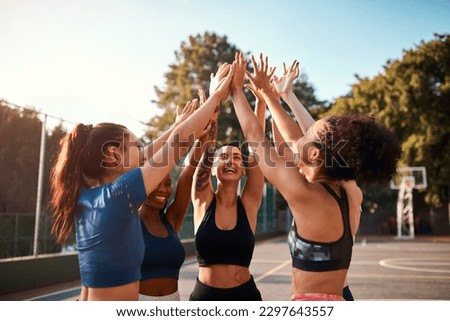 One last cheer. a diverse group of friends raising their hands together before playing basketball during the day.