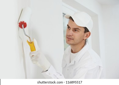 One Male House Painter Worker Painting And Priming Wall With Painting Roller