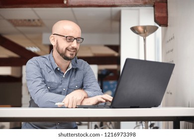 One Man, 30-39 Years Old, Using Laptop, In Modern Office Interior. Brightly Lit.