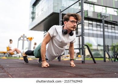 One man adult caucasian male doing push-ups at outdoor gym training center on open in the city in day real people exercise workout and recreation concept copy space