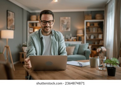 one man adult caucasian male with beard work on his laptop computer at home happy smile success freelance entrepreneur or remote work concept - Powered by Shutterstock