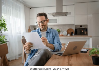 one man adult caucasian male with beard work on his laptop computer at home happy smile success freelance entrepreneur or remote work concept - Powered by Shutterstock