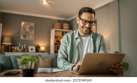 one man adult caucasian male with beard work on his laptop computer at home happy smile success freelance entrepreneur or remote work concept - Powered by Shutterstock