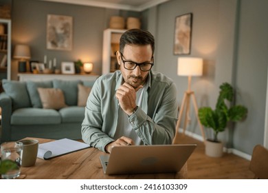 one man adult caucasian male with beard work on his laptop computer at home solve problem freelance entrepreneur or remote work concept - Powered by Shutterstock