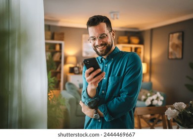 one man adult caucasian male use mobile phone smartphone at home for online web internet search or sms text messages texting  - Powered by Shutterstock