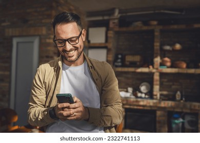 One man caucasian male with beard and eyeglasses sit outdoor in sunny day wear shirt use mobile smart phone for sms text messages browse internet online or video call use app copy space real people - Powered by Shutterstock