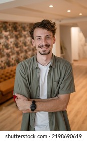 One Man Front View Portrait Waist Up Standing Indoor In Cafe Or Restaurant Lobby Happy Smile Confident Wear Olive Shirt With Modern Haircut Mustaches And Beard Looking To The Camera