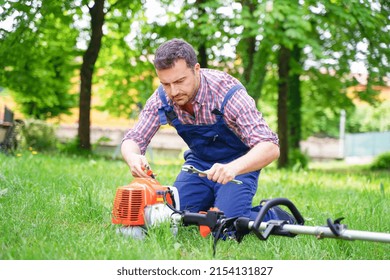 One Man Repairing Broken Brushcutter In The Garden