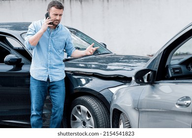 One man reporting car crash damage calling insurance roadside service - Shutterstock ID 2154541823
