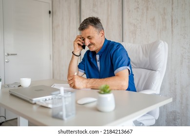 One Man Senior Entrepreneur Active Caucasian Male Making A Phone Call Talking While Sitting At The Desk Table Working At Office Manager And Small Business Real People Copy Space