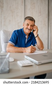 One Man Senior Entrepreneur Active Caucasian Male Making A Phone Smiling Call Talking While Sitting At The Desk Table Working At Office Manager And Small Business Real People Copy Space