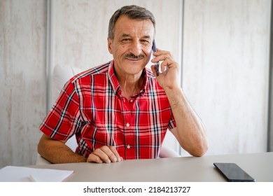 One Man Senior Entrepreneur Active Caucasian Male Making A Phone Call Talking While Sitting At The Desk Table Working At Office Manager And Small Business Real People Copy Space