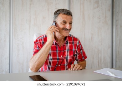 One Man Senior Entrepreneur Active Caucasian Male Making A Phone Call Talking While Sitting At The Desk Table Working At Office Manager And Small Business Real People Copy Space