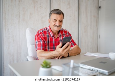 One Man Senior Entrepreneur Active Caucasian Male Making A Phone Call Talking While Sitting At The Desk Table Working At Office Manager And Small Business Real People Copy Space