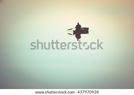 one man in a small boat sailing boat on the lake river rowing oars. River with a smooth mirror surface of the water. Weather quiet, calm, windless