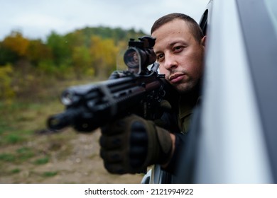 One Man Special Force Police Or Terrorist Holding Automatic Weapon Shooting And Aiming From The Car Anti-terrorist Unit On The Mission Under Attack In Vehicle Copy Space Side View