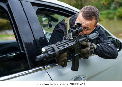 One Man Special Force Police Or Terrorist Holding Automatic Weapon Shooting And Aiming From The Car Anti-terrorist Unit On The Mission Under Attack In Vehicle Copy Space Side View