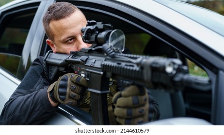 One Man Special Force Police Or Terrorist Holding Automatic Weapon Shooting And Aiming From The Car Anti-terrorist Unit On The Mission Under Attack In Vehicle Copy Space Side View