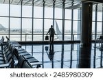 One man standing at the airport gate waiting his flight with delay or canceled. Traveler people lifestyle in indoor leisure activity. One tourist with backpack wait to fly with airplane for vacation