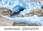 One Man standing in front of Glacier and melt water river. Nigardsbreen, Jostedalsbreen National Park, Norway.