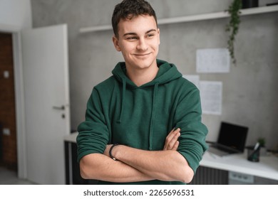 one man teenager stand in room at home wear green hoodie waist up - Powered by Shutterstock