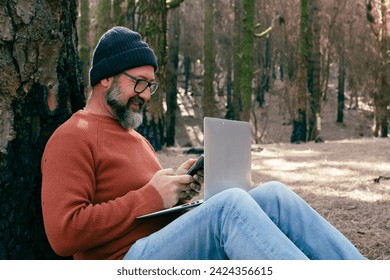 One man using technology connection in nature park forest woods. Remote worker small travel business lifestyle people. Working in the nature alternative office. Small business. Travelers job life
