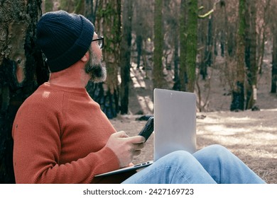 One man using technology connection in nature park forest woods. Remote worker small travel business lifestyle people. Working in the nature alternative office. Small business. Travelers job life