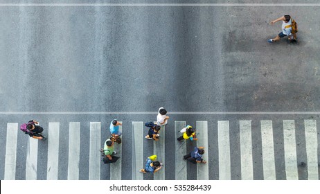 the one man walk converse,  the busy city crowd move to pedestrian crosswalk on businees traffric road (Aerial photo, top view)  - Powered by Shutterstock