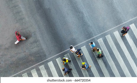 The One Man Walk Converse,  The Busy City Crowd Move To Pedestrian Crosswalk On Business Traffic Road (Aerial Photo, Top View) 