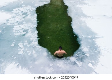 One Man In Water Hole Of Icy Water Covered With White Snow And Ice Practicing Cold Water Therapy, 