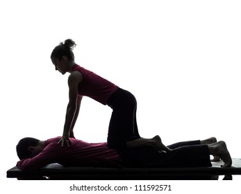 One Man And Woman Perfoming Thai Massage In Silhouette Studio On White Background