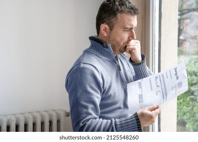 One man worried about bills reading energy increase costs - Shutterstock ID 2125548260