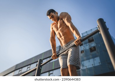 One man young adult caucasian male athlete training at outdoor open gym pull ups exercise healthy lifestyle and recreation training concept in the city in summer day real people copy space - Powered by Shutterstock