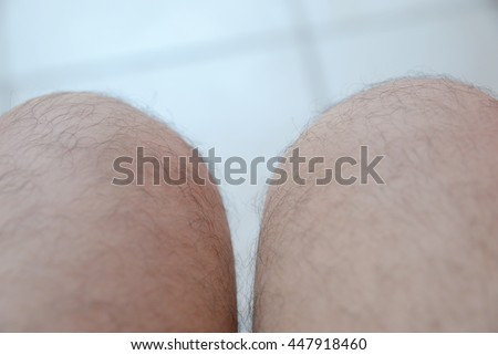 One mans hairy leg isolated on white background