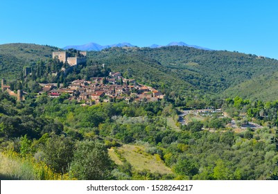 One Of Many Charming Mountain Villages In South Of France. Medieval Castle, Stone Walls And Family Houses On A Hilltop Surrounded By Greenery. Southern Europe