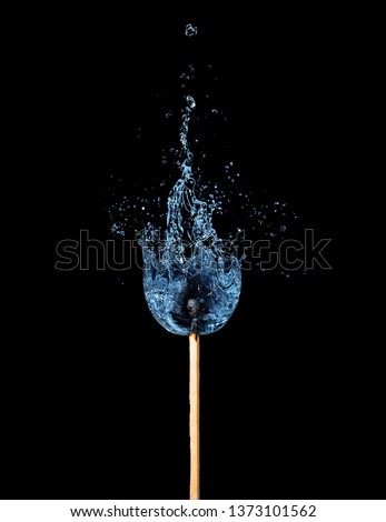 One match that burns with water splash. Conceptual ecological and nature photo against the forest fires. Isolated on black.