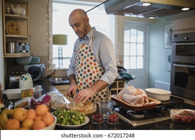 One mature man is preparing a christmas dinner in the kitchen of his home. He is peeling potatoes. - Powered by Shutterstock