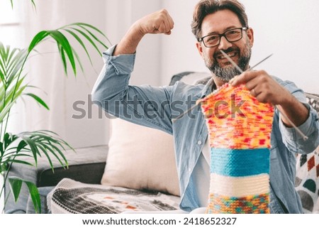 Similar – Image, Stock Photo A man in knitted sweater and light pants helps a small child with red cap to explore on the beach