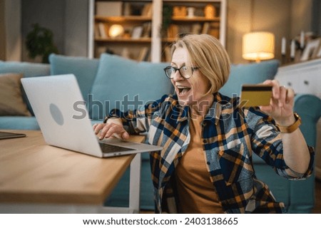 One mature senior woman grandmother sit at home use credit or debit card for online shopping browse internet stores buying stuff use digital tablet real people copy space