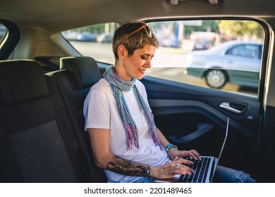 One Mature Woman Caucasian Female Sitting On The Back Seat Of The Car Working On Laptop Computer In Summer Day With Short Gray Hair Modern Manager Or Business Owner On Road Wearing Casual Copy Space